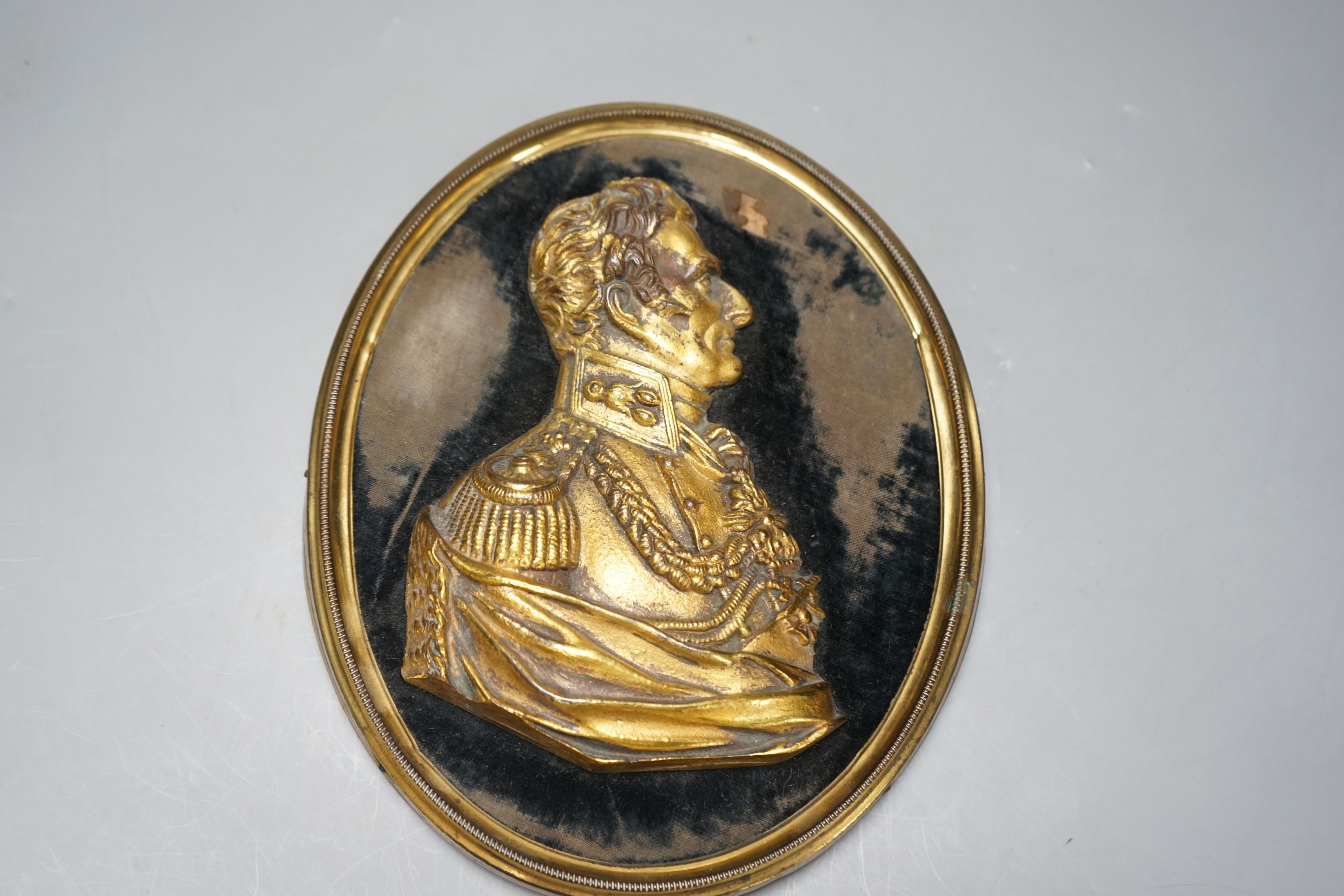 A gilt metal portrait profile relief, The Duke of Wellington, set on black velvet ground, brass frame, 23cms high